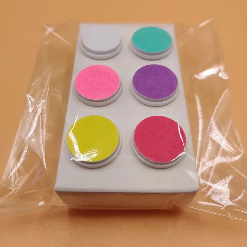 Electric baby trimmer safe showing product with different trimmer pad options top angle