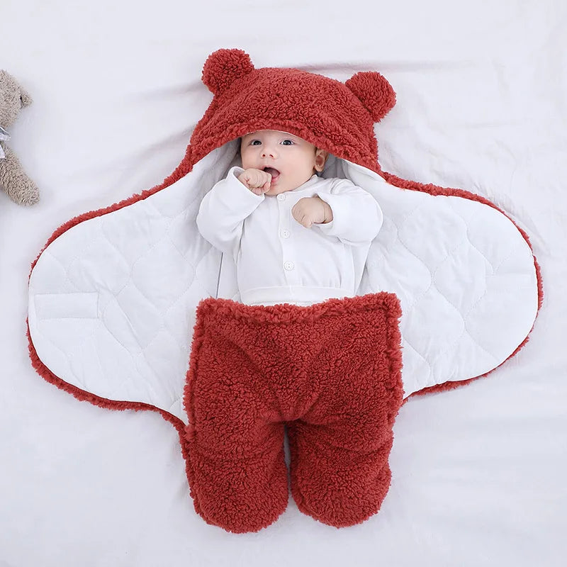 Cute and cuddly red baby bear blanket with baby wrapped up cozy showing little arms and hands versatile for baby's temperature comfort 